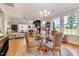 Elegant dining area with hardwood floors, stylish chandelier, and abundant natural light from large windows at 1004 Sounding Ln, Durham, NC 27703