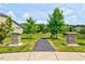 Well-manicured community entrance flanked by stone pillars and lush landscaping at 1004 Sounding Ln, Durham, NC 27703