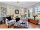 Bright sunroom with lots of windows, hardwood floors, and comfortable armchairs at 1004 Sounding Ln, Durham, NC 27703