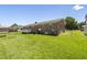 Backyard featuring a well-maintained lawn, a small deck, and a brick home exterior at 117 James Dr, Pine Level, NC 27568