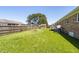 Backyard featuring a well-maintained lawn, mature trees, and a brick home exterior at 117 James Dr, Pine Level, NC 27568