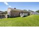 Backyard featuring a well-maintained lawn, a small deck, and a brick home exterior at 117 James Dr, Pine Level, NC 27568