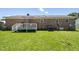 Backyard featuring a well-maintained lawn, a small deck, and a brick home exterior at 117 James Dr, Pine Level, NC 27568