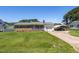 Charming brick home featuring a manicured lawn, attached garage, and a convenient carport on a sunny day at 117 James Dr, Pine Level, NC 27568