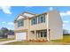Two-story home featuring a brick and vinyl exterior with gray shutters, front entry columns, and a concrete driveway at 119 Leven Dr, Gibsonville, NC 27249
