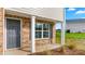 Home exterior featuring a brick facade, gray front door with white trim, and a covered front porch with white columns at 119 Leven Dr, Gibsonville, NC 27249