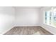 Empty room featuring hardwood floors, white walls, base trim, and natural light from the windows at 119 Leven Dr, Gibsonville, NC 27249