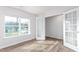 Bright room with wood-look flooring, white walls, large windows, and glass panel doors at 119 Leven Dr, Gibsonville, NC 27249