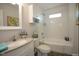Bright bathroom featuring a tub with shower, grey granite counters, and white subway tile at 1206 Downing Rd, Raleigh, NC 27610