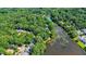 An aerial view of a wooded community beside a lake with waterfront homes nestled between tall trees at 125 Chimney Rise Dr, Cary, NC 27511