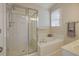 Bright bathroom featuring a glass shower, separate tub, and neutral tile at 125 Chimney Rise Dr, Cary, NC 27511