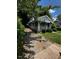 Single-story home with a long driveway, featuring stone accents and mature trees for added privacy at 1305 E Jones St, Raleigh, NC 27610