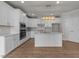 Bright kitchen with white cabinets, a kitchen island with quartz countertop, and stainless steel appliances at 1400 Gathering Park Cir # 203, Cary, NC 27519