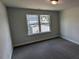 This comfortable bedroom features soft carpet, neutral paint, and a window overlooking a well kept lawn at 147 River Chapel Dr, Fuquay Varina, NC 27526