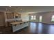 Open-concept kitchen with stainless appliances, gray cabinets, a granite island, and dining area at 147 River Chapel Dr, Fuquay Varina, NC 27526