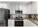 Granite counters accent this kitchen with stainless appliances and modern, white cabinetry at 1508 Carroll Heights Rd, Zebulon, NC 27597
