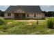Back view of new construction home with black roof, framed windows, and covered porch at 171 Surles Landing Way, Benson, NC 27504
