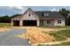 New construction home with black roof, framed windows, and an attached, unfinished two-car garage at 171 Surles Landing Way, Benson, NC 27504
