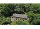 Aerial view of a single-story home surrounded by lush greenery, trees and a well maintained lawn at 18 Red Pine Rd, Chapel Hill, NC 27516