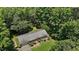 Aerial view of single-story home surrounded by green lawns, mature trees, and natural wooded areas at 18 Red Pine Rd, Chapel Hill, NC 27516