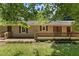 A nice backyard with grass, a wooden deck, brick details, and views of the house at 18 Red Pine Rd, Chapel Hill, NC 27516