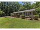 View of the front exterior, featuring a well-kept lawn, brick pathway, and ample foliage and large shade trees at 18 Red Pine Rd, Chapel Hill, NC 27516