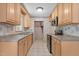 Traditional kitchen featuring light wood cabinets, tile countertops and floors, stainless steel appliances, and vintage wallpaper at 18 Red Pine Rd, Chapel Hill, NC 27516
