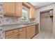 Traditional kitchen featuring light wood cabinets, tile countertops, stainless steel dishwasher, and vintage wallpaper at 18 Red Pine Rd, Chapel Hill, NC 27516