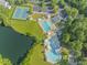 This aerial view showcases a community pool and tennis court near a pond at 208 Holly Green Ln, Holly Springs, NC 27540