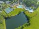 Aerial view features a lake with trees, a pool and tennis courts in the community at 208 Holly Green Ln, Holly Springs, NC 27540