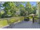 View of the gray wood back deck with seating and a view to the large yard at 208 Holly Green Ln, Holly Springs, NC 27540