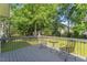 View of the gray wood back deck with outdoor seating, overlooking a large yard at 208 Holly Green Ln, Holly Springs, NC 27540
