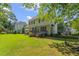 Spacious backyard featuring a green lawn, mature trees, and a wooden deck at 208 Holly Green Ln, Holly Springs, NC 27540
