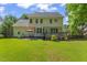 Two-story home featuring a backyard with green lawn, patio and a wood deck at 208 Holly Green Ln, Holly Springs, NC 27540