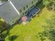 Aerial view of the backyard featuring a deck, patio with seating, and a lush lawn at 208 Holly Green Ln, Holly Springs, NC 27540