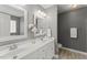 Gray bathroom featuring a double sink vanity, two mirrors, and bright lighting at 208 Holly Green Ln, Holly Springs, NC 27540