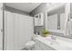 Well-lit bathroom with a vanity, toilet and a shower with white curtain and a plant at 208 Holly Green Ln, Holly Springs, NC 27540