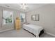 Clean bedroom with light colored wooden dresser, and two windows at 208 Holly Green Ln, Holly Springs, NC 27540