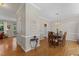 Hardwood floors lead to a dining area with a chandelier over a wooden table at 208 Holly Green Ln, Holly Springs, NC 27540