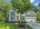 Charming two-story home featuring a well-manicured lawn and attached two-car garage at 208 Holly Green Ln, Holly Springs, NC 27540
