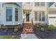 Close up of the front entrance with brick stairs, black railing and bay window at 208 Holly Green Ln, Holly Springs, NC 27540