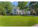 Lush front lawn enhances this home's curb appeal with mature trees and established landscaping at 208 Holly Green Ln, Holly Springs, NC 27540