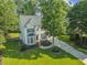 Beautiful two-story home with mature trees, well-kept lawn, and inviting front facade at 208 Holly Green Ln, Holly Springs, NC 27540