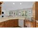 Charming kitchen with wood cabinets, sink, dishwasher, and a window overlooking the backyard at 208 Holly Green Ln, Holly Springs, NC 27540
