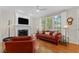The living room features a fireplace, hardwood floors, and natural light from many windows at 208 Holly Green Ln, Holly Springs, NC 27540