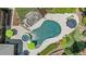 Aerial view of the stunning kidney-shaped pool with spa, umbrellas, and lush landscaping, a backyard paradise at 2112 Colin Hill Ct, Wake Forest, NC 27587