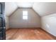 Unfinished attic space with hardwood floors, a window and a slanted ceiling at 2112 Colin Hill Ct, Wake Forest, NC 27587