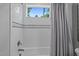 Bathtub with white tile and gray shower curtain and window view to the outdoors at 2112 Colin Hill Ct, Wake Forest, NC 27587