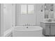 The soaking tub is lit by natural light coming from the window with privacy shutters at 2112 Colin Hill Ct, Wake Forest, NC 27587