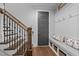 Hallway featuring wooden staircase and mudroom area with gray bench, coat hooks, and storage baskets at 2112 Colin Hill Ct, Wake Forest, NC 27587